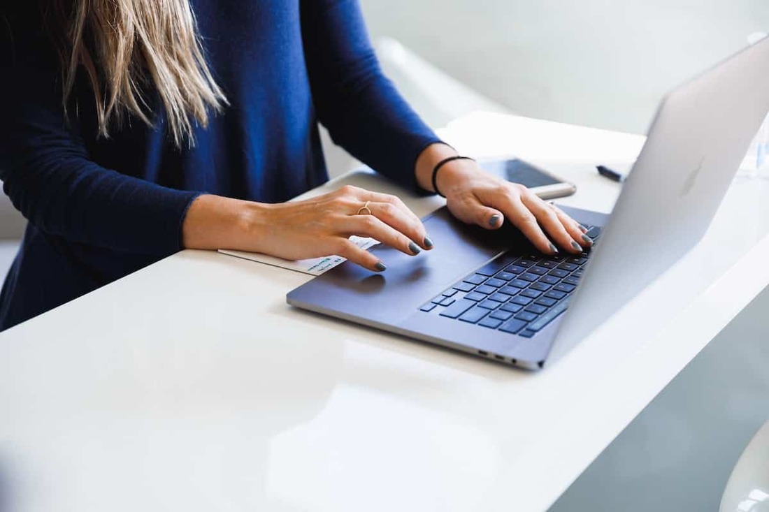 Image contains a woman using a laptop