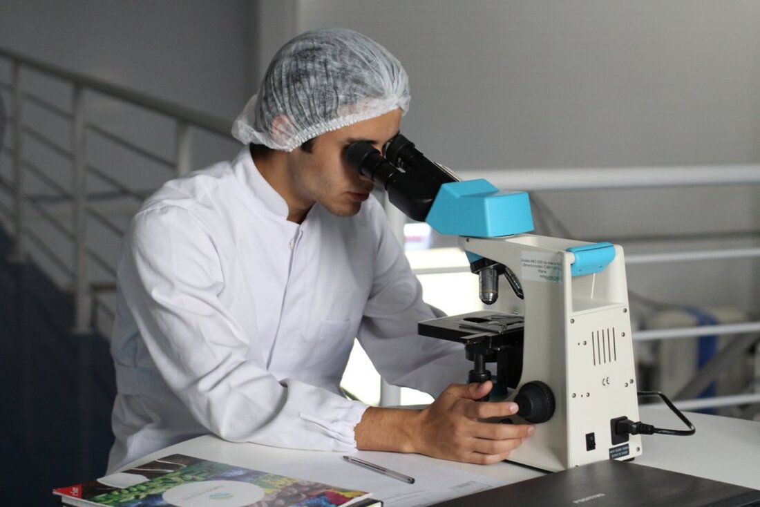 Image contains a person using a microscope
