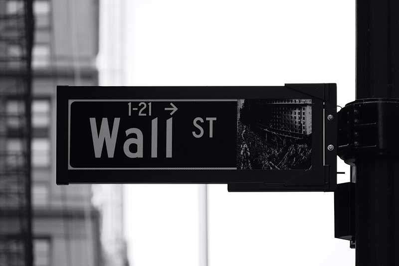 pre money vs post money valuation: this image shows a wall street sign, in black and white, with a blurred background