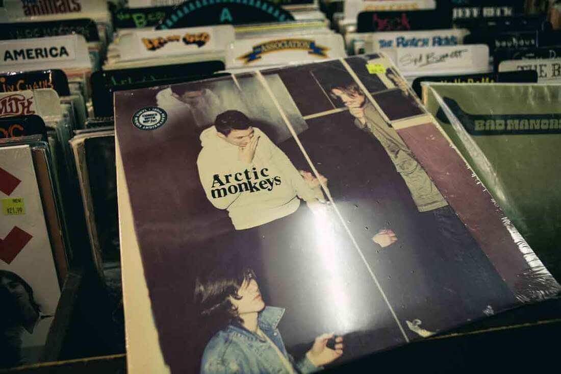 An Arctic Monkeys LP in front of a pile of LPs. This band was essential to what happened to myspace