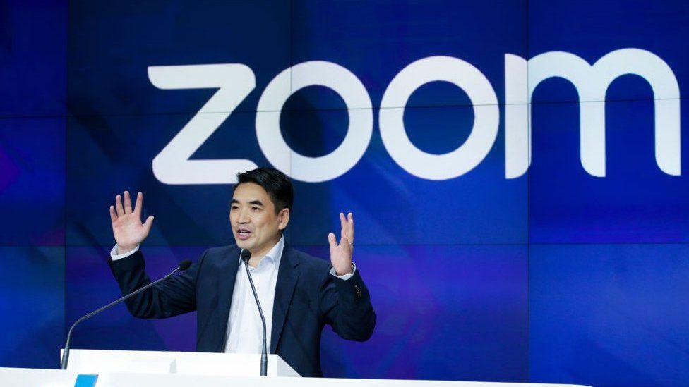 When Zoom was created image: Eric Yuan speaks in front of a large screen that says Zoom in white and blueS