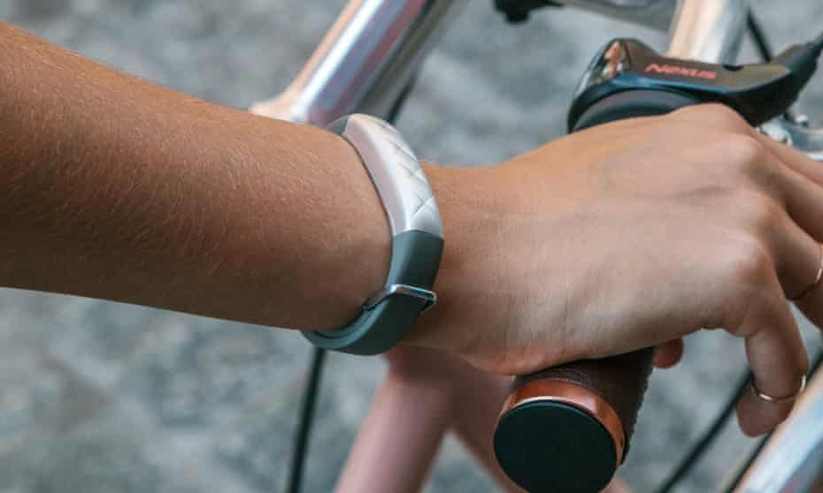 Image for What Happened To Jawbone: a hand holding a bike bar, with a wearable