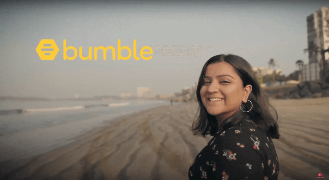 Image for Tinder Vs Bumble: A woman smiles at the camera, with a beach for a background, and the words Bumble on the top left